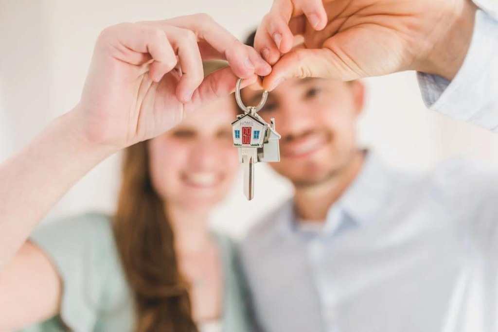 An image of a happy couple holding and showing a house key