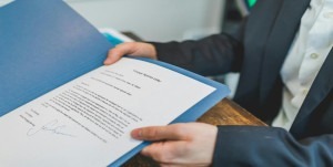 A person showing a printer document on a blue folder