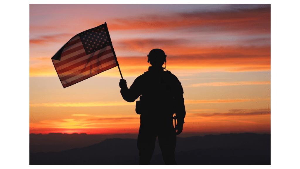 Silhouette of a U.S. military service member holding an American flag at sunset, representing VA home loan eligibility in Colorado