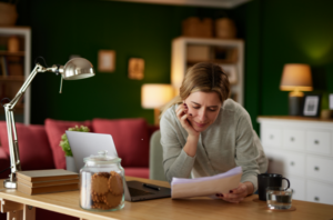 Woman reviewing financial documents at home while calculating income from bank statements for a Colorado mortgage.