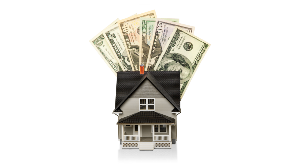 Miniature investment property model with US dollar bills fanned out behind the roof, symbolizing cash-out refinance equity.