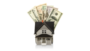 Miniature investment property model with US dollar bills fanned out behind the roof, symbolizing cash-out refinance equity.
